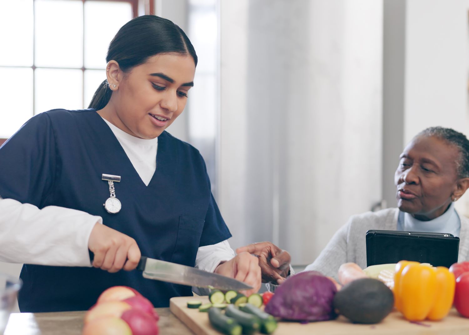 caregiver-cooking-senior-woman-home-with-healthy-food-vegetables-nutrition-healthcare-retirement-nurse-helping-elderly-person-kitchen-with-diet-online-recipe-tablet-1